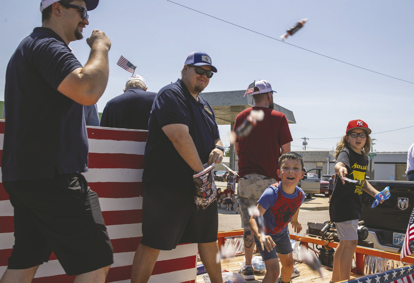 Parade participants toss candy to spectators lining the streets during the annual Crescent Glory Days Fourth of July Parade on July 4 in downtown Crescent. Photo by Brent Fuchs