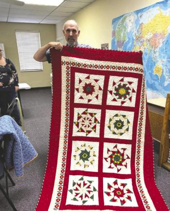 Noble thread member showcasing a completed quilt.