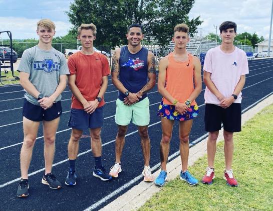 McCoy (center) stands with members of the Guthrie High School track team