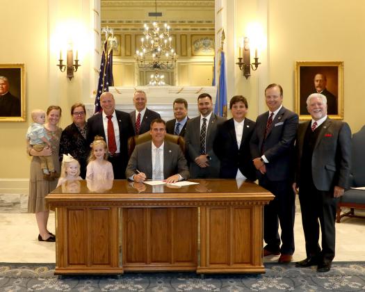(Bottom row, L to R) Rep. Jim Olsen’s granddaughters Avery and Adelynne, and Gov. Kevin Stitt. (Top row, L to R) Rep. Jim Olsen’s grandson Ezekiel, daughter Anna, wife Rebecca, Rep. Jim Olsen, Rep. Gerrid Kendrix, Oklahoma Faith Leaders member John Johnson, Sen. Nathan Dahm, Rev. Paul Abner’s son Jackson, leader of Oklahoma Faith Leaders Rev. Paul Abner, and Oklahoma Faith Leaders member Randall Drake.