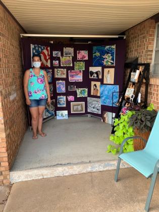 Erica Bonavida, photo of artist with artwork on porch during OK Art Crawl 2020