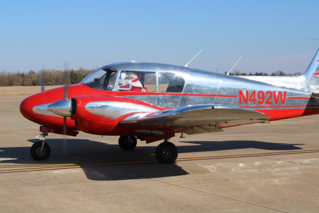 Santa waves inside plane as he enters the Guthrie-Edmond Regional Airport.