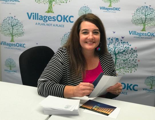 Amy Shirola, operations manager, prepares VillagesOKC anniversary celebration invitations for mailing.
