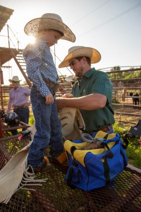 Five-year-old Sloan Blankenship of Guthrie gets help from his dad, Rylin, while preparing for the mutton busting event during the Guthrie Youth Rodeo on Saturday at the Logan County Fairgrounds.