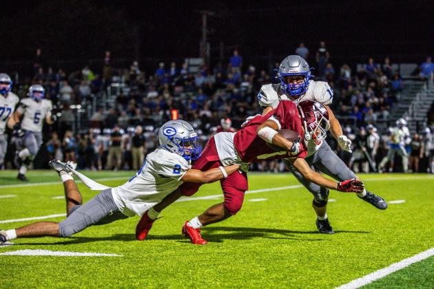 Guthrie defenders Skylor Scamman, left, and Rowan Mchone bring down Tuttle Receiver Jordan Lane during the game won by the Tigers, 38-13