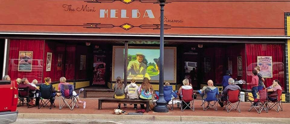 Families watching a free show at the Mini Melba Cinema in Downtown Guthrie.