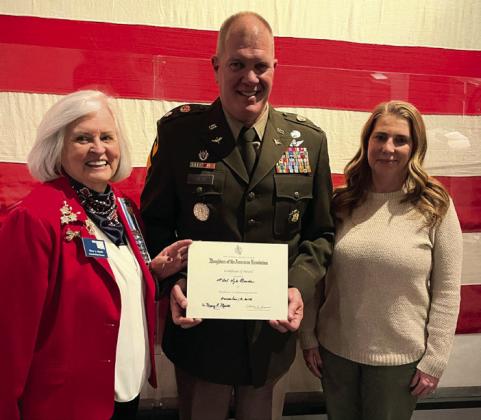 Dr. Mary Merritt, regent of the Samuel King Chapter NSDAR, presents Lt. Col. Kyle Brede with the NSDAR Community Service Award on Dec. 18, 2025. Photo, Nikki Bos