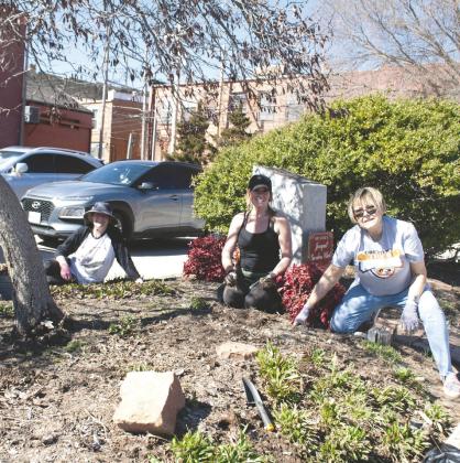 Members of the Guthrie Jonquil Garden Club clean flower beds ahead of spring planting.