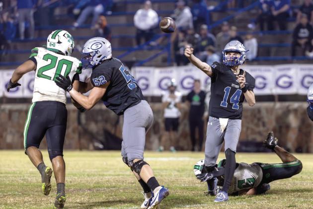 Senior Guthrie quarterback Daelon Rice releases a pass under pressure during last Friday’s playoff game against Bishop McGuinness at Jelsma Stadium. Photo by Brent Fuchs.