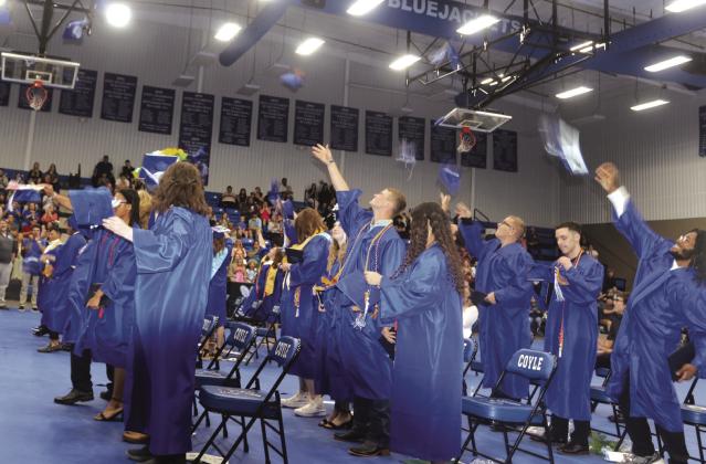 Coyle Graduation-Caps in the air.
