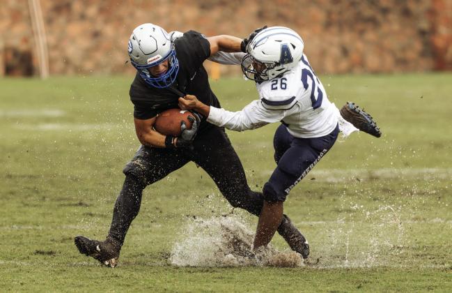 Zane Thomas attempts to shed an Altus tackler on a rain-soaked Jelsma Stadium field Saturday, Oct. 25. The Bluejays rallied to tie the game in regulation then won 41-35 in overtime.