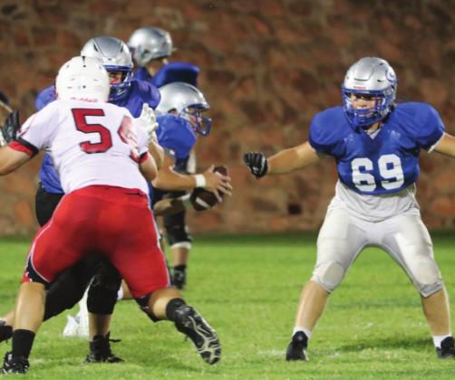 Guthrie FBoffense scrimmage against Bishop Kelly as coach looks on