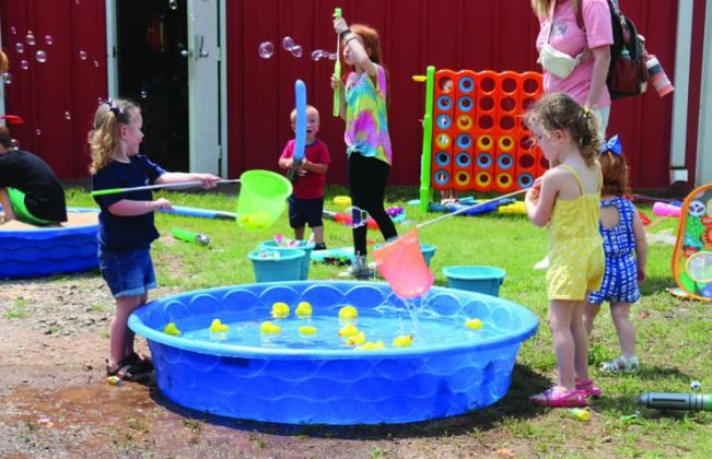Kids playing with bubbles and ducks at Mulhall Days.