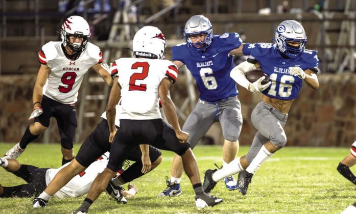 Guthrie's Codie Carlock advances the football as teammate Mason Russell looks to make a block in the Bluejays' 42-10 win Sept. 12.