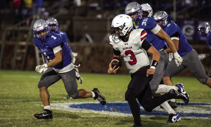 Duncan quarterback Sawyer Rice runs the football as Guthrie defenders Zane Thomas (1) and Kade Barton (35) close in. The Bluejays won 42-10 at Jelsma Stadium on Sept. 12.