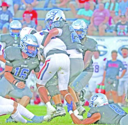 Guthrie defenders Tyler Gettings(8),Josh Varnell (16) and Nico Pena (25) team up to tackle Ponca City runner.