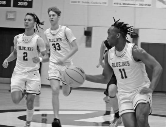 Alex Clark drives to basket as TJ Kelly and Ryder Franz follows the play