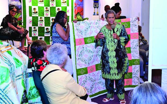 Dr. o Ann lark, retired from Langston University, speaks to the crowd about her African quilts.