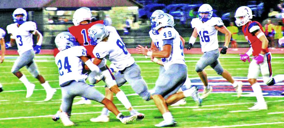 Guthrie’s Kyran Axtell (24), Brayden Chaney (8) take on Ponca City runner with rest of defense in pursuit. Photo courtesy of Ponca City News.