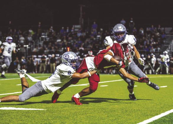 Guthrie defenders Skylor Scamman, left, and Rowan Mchone bring down Tuttle Receiver Jordan Lane during the game won by the Tigers, 38-13.