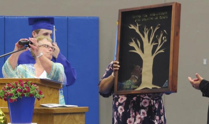 Senior gift to Mrs. Larman, Dawna Smith, Ryan Weathers and Elijah Julian look on