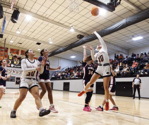 Lady Tigers Trinity Webster goes up for a shot as teammate Tessa Haley and Minco defenders battle for position underneath during a girls basketball game. Photo Brent Fuchs