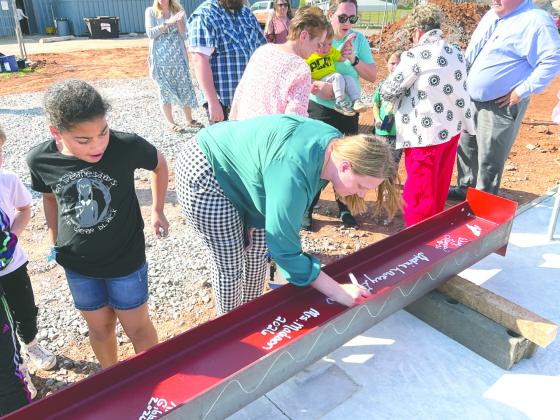 Attendees sign a structural beam during the beam signing ceremony at Coyle Public Schools, leaving their mark on the district’s new Agricultural Education and STEM facility. Photo courtesy Renaissance Architecture.
