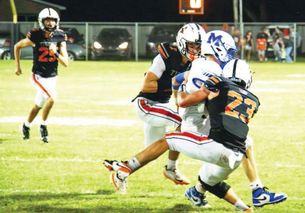 A pair of defenders tackle a Mooreland ball carrier during the Tigers’ 43-8 win on homecoming.
