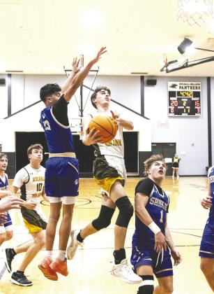 Mulhall-Orlando guard Wade Blagden attempts a layup as Shidler players defend. Photo by Brent Fuchs