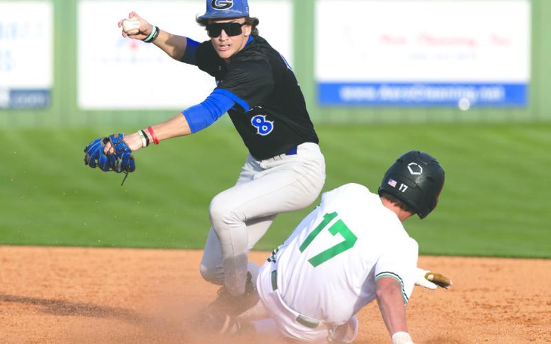 Guthrie’s Lance Evans (8) throws to first base after fielding the ball Friday, March 13, 2026, at Bishop McGuinness High School. Guthrie defeated Bishop McGuinness 8-5.