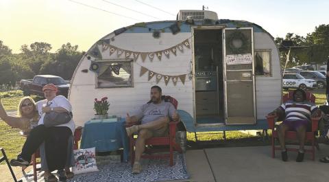 Attendees enjoy a break outside a vintage camper during the sixth annual Hoppy Camper fundraiser at Camp Twin Cedars in Guthrie, supporting the nonprofit camp’s programs. Photo courtesy of Cody Lawson