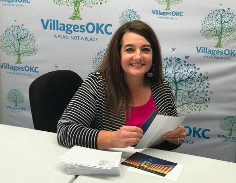 Amy Shirola, operations manager, prepares VillagesOKC anniversary celebration invitations for mailing.