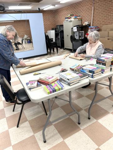Volunteers wrap books for the Friends of the Library’s Blind Date with a Book display.