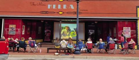 Families watching a free show at the Mini Melba Cinema in Downtown Guthrie. 