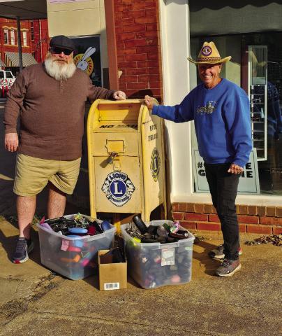 Guthrie Noon Lions Club members Troy Jenkins and Steve Gentling stand with the donation box located outside Vision Source in Guthrie, Oklahoma.