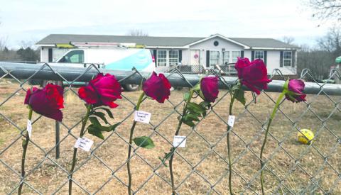 Red roses are placed on a fence near the scene of an apparent murder-suicide in Logan County in tribute. Photo by Bobbi Waddell.