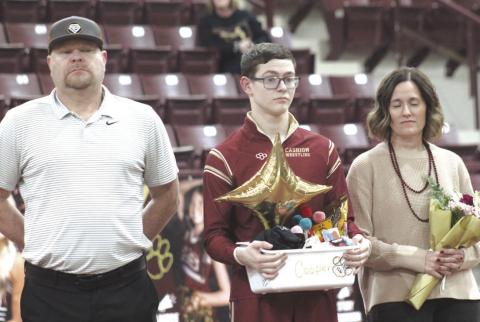 Cashion wrestling senior Cooper McGuire with his family on Senior Night. Photo by George McCormick