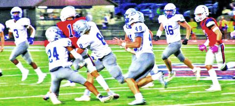 Guthrie’s Kyran Axtell (24), Brayden Chaney (8) take on Ponca City runner with rest of defense in pursuit. Photo courtesy of Ponca City News.