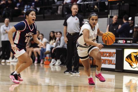 Aja Adams-House drives toward the basket during a girls basketball game as Minco closes in. Photo Brent Fuchs