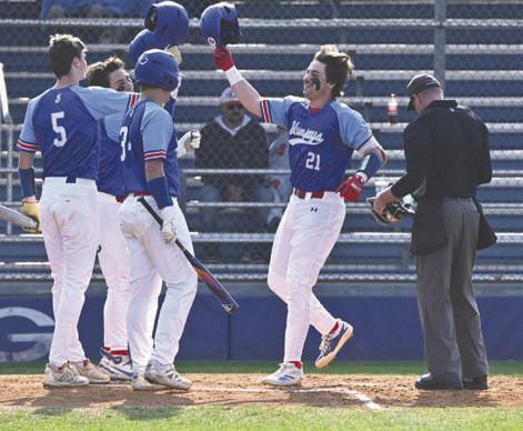 Guthrie’s Owen Wilder celebrates with his teammates at home plate on March 3. Photo by Brett Tennyson
