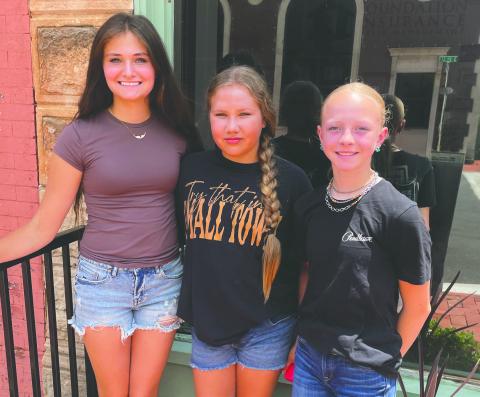 Carlee Weinberger (left), Stevie Kurle (center) and Brendle Mott, all of North Dakota, take a break from competition at the National Junior High Finals Rodeo at the Lazy E Arena in Guthrie, Okla., to explore downtown shopping. The young competitors said meeting new people, building friendships and experiencing the rodeo community have been highlights of their week at the national event. Photo by Guthrie News Leader.