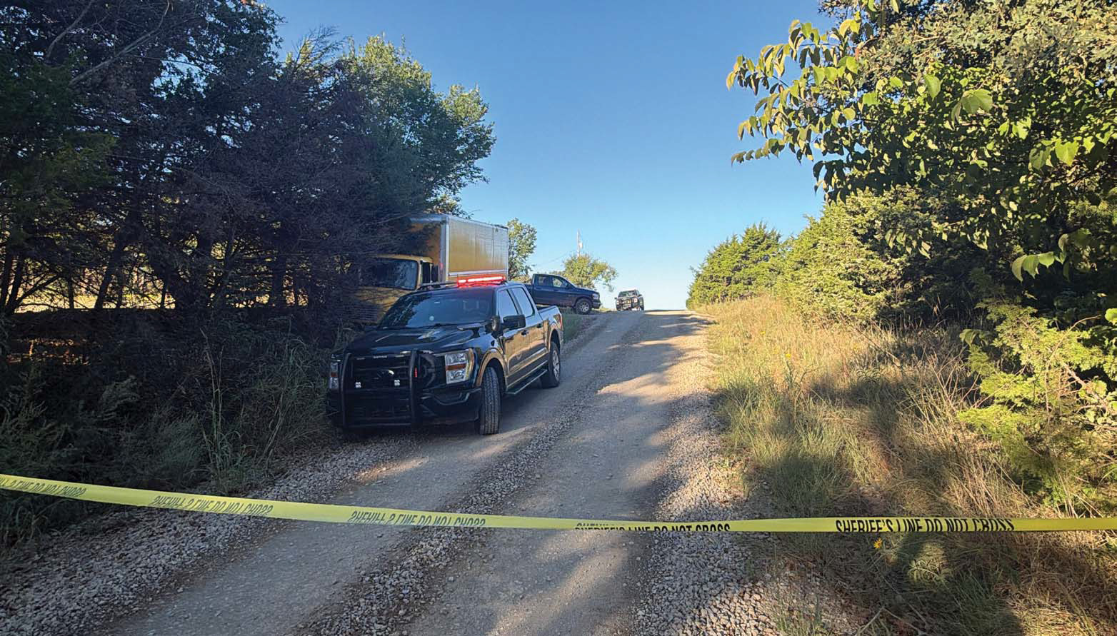 Law enforcement vehicles and police tape mark the scene Monday morning near the 11000 block of East College Avenue and Autumn Woods Farm Road following a deadly altercation involving two delivery workers. One person was killed and another was injured in the incident. Photo courtesy of Logan County Sheriff’s Office.
