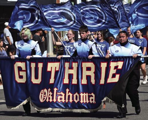 The Guthrie High School band and color guard lead the way through downtown during the Guthrie Homecoming parade Sept. 18, helping kick off a day of “Jurassic Jays” celebrations. Photo by Brett Tennyson
