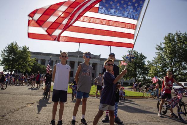Children proudly hold an American flag in front of the historic Masonic Temple before the start of Guthrie's seventh annual Freedom Ride. Photo by Brent Fuchs