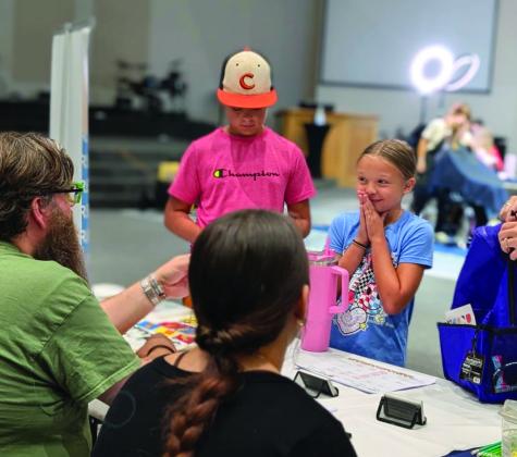 A local family gathers information from a booth during Guthrie’s annual Back to School Bash at Community Church. Photo courtesy of Guthrie Chamber of Commerce.