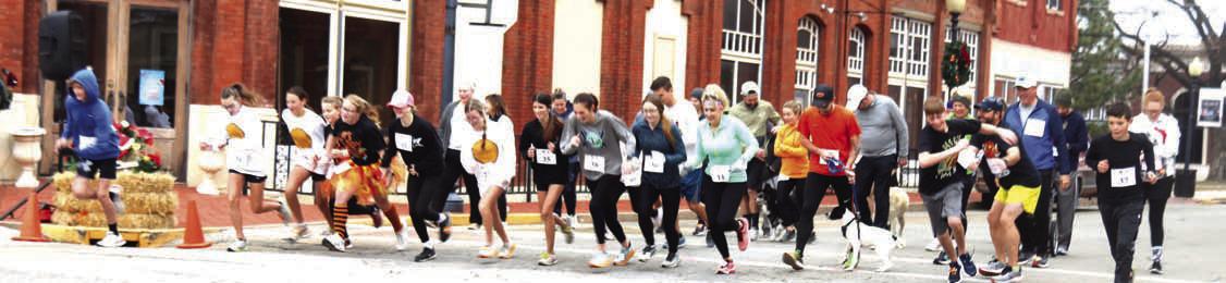 Pictured, Above, the start of the race for the first ever Guthrie Turkey Trot sponsored by the American Legion to benefit local veterans. There were 40 runners that showed up for the first race through the downtown area on a chilly Thanksgiving morning. Kamryn Boller won the race. Photo by Mike Monahan