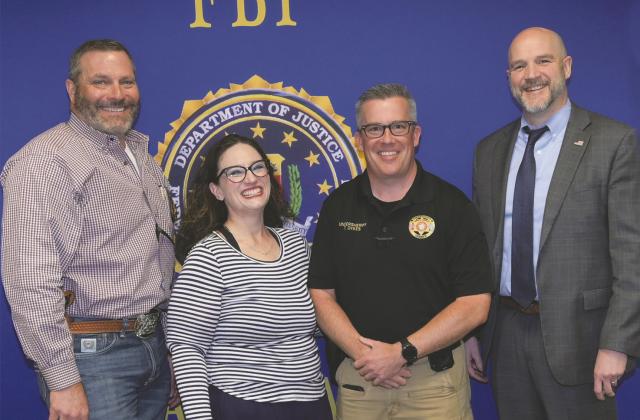 From left, Logan County Sheriff Damon Devereaux, Nikki Dykes, Logan County Undersheriff Troy Dykes and FBI Special Agent in Charge Douglas Goodwater.