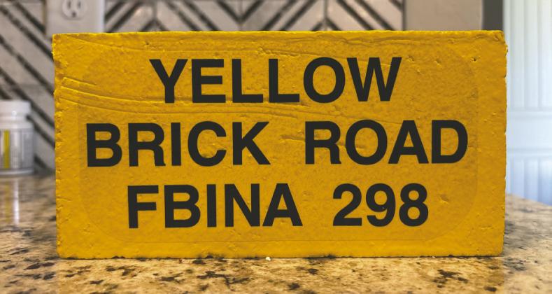 Logan County Undersheriff Troy Dykes displays the commemorative yellow brick awarded to graduates who complete the FBI National Academy’s challenging “Yellow Brick Road” endurance course.