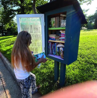 Friends of the Guthrie Library board member Susan Hawkins adds books to a Little Library in Guthrie as part of the Friends’ 40th anniversary celebration and ongoing effort to spread the joy of reading throughout the community. Photo Courtesy of Friends of the Guthrie Library.