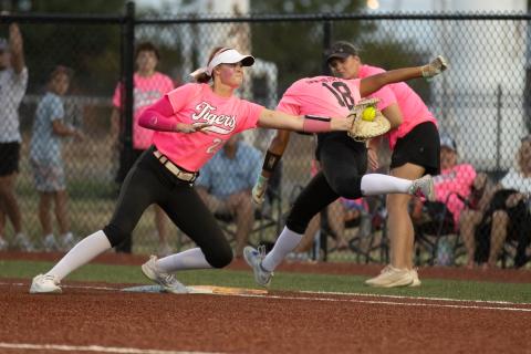 Crescent Lady Tigers first baseman Ava Beaty, No. 22, reaches for the tag on Cashion’s Lily Stuemky, No. 18, during their pink out game on Sept. 15. Photo by Brent Fuchs